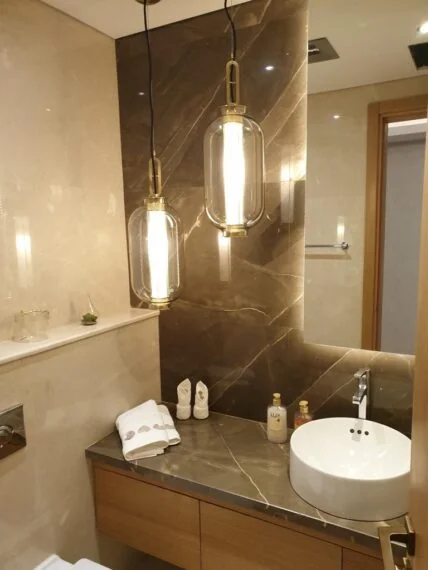 Bathroom with stone finishes and pendant lights